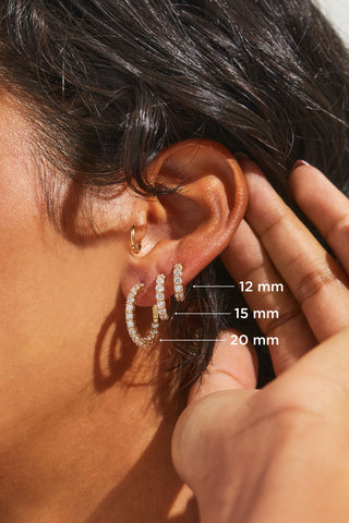 Image shows a close up of models ear in profile with three different cubic zirconia hoop earrings ranging in size from 12mm to 20mm