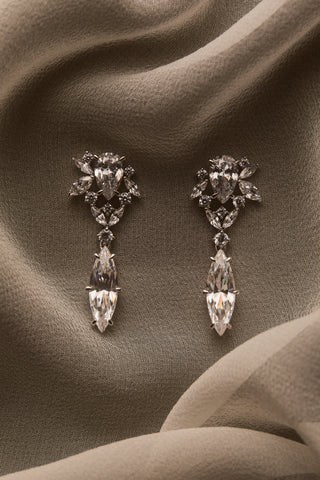 NADRI CANNES DROP EARRINGS PLACED ON A DRAPED SHEER, BLUE FABRIC
