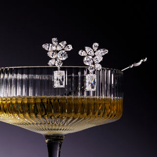 Image of Bonne Anne Cluster Drop CZ Earrings balanced on the edge of a cocktail glass