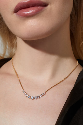 MODEL IS WEARING PERFECT TENNIS GRADUATED CZ FRONTAL NECKLACE IN GOLD PLATING.