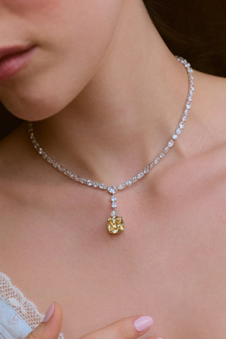 CLOSE UP OF A MODEL’S CHEST WEARING THE SOLEIL YELLOW CZ DRAMA STATEMENT Y NECKLACE