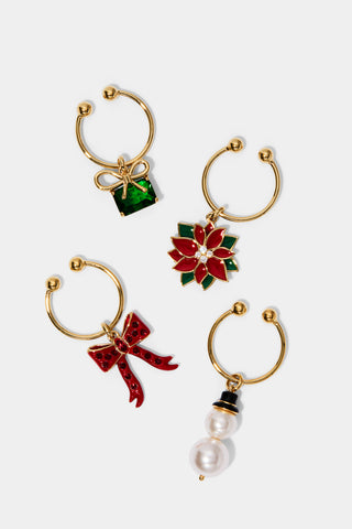 Set of four decorative wine glass charms with poinsettia, bow, present and pearl snowman designs on a white background.