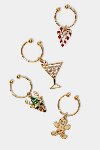 Set of four gold wine charms with festive designs on a white background. The charms include a reindeer, gingerbread man, peppermint martini, and a candy cane striped heart.
