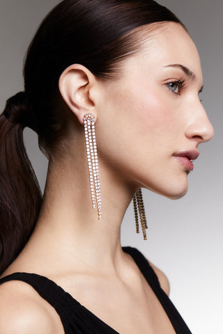 Side profile image of a model wearing long, dangling Hollywood Chandelier earrings with a neutral background.