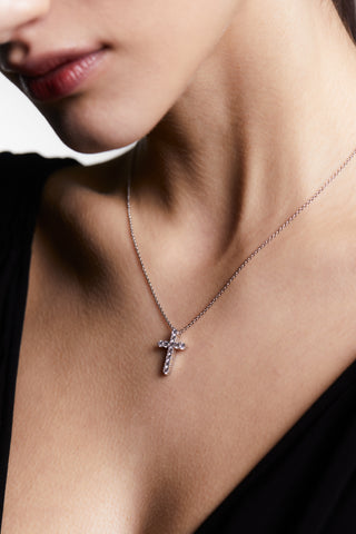 Close-up of a model wearing a rhodium plated cz cross pendant.