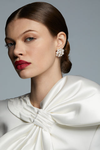 LONDON LARGE CLUSTER PEARL EARRINGS ON MODEL. HER HAIR IS IN A SLICK BACK BUN AND RED LIPSTICK WITH A WHITE BOW BRIDAL STYLE TOP.