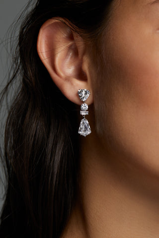 LUXOR KITE CZ DROP EARRINGS ON MODEL. IT IS A CLOSE UP IMAGE OF HER EARS WITH HAIR TUCKED BACK. 