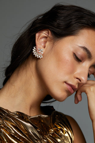 LUXOR CZ FAN JACKET EARRINGS ON MODEL. SHE IS RESTING HER HEAD ON HER HAND WITH HER EYES CLOSED. HAIR IS PULLED BACK WITH EAR FULLY VISIBLE SHOWING THE DETAIL OF THE FRONT BACK EARRING. SHE IS WEARING A SHIMMERY GOLD DRESS. 