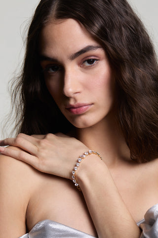 A MODEL STARING AT THE CAMERA AS HER HAND IS PLACED ON HER SHOULDER ACROSS HER BODY, WEARING THE LUCIA MIXED CZ LINE BRACELET
