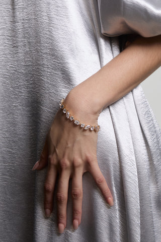 A CLOSE UP OF A MODEL’S HAND ON HER HIP WEARING THE LUCIA MIXED CZ LINE BRACELET AND A LONG, WHITE GOWN