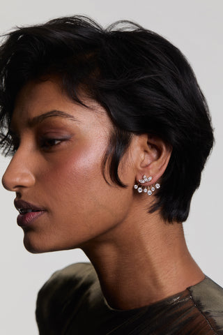 SIDE PROFILE OF A MODEL WEARING LUCIA FRONTBACK JACKET EARRINGS, STYLED WITH SHORT HAIR AND A METALLIC TOP