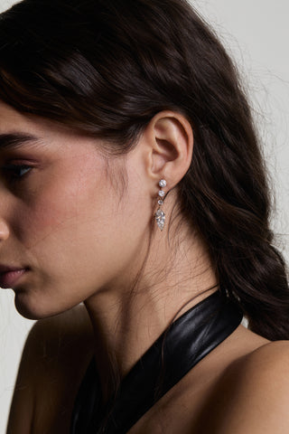 CLOSE UP SIDE PROFILE OF A MODEL WEARING LUCIA J HOOP DROP EARRINGS, WITH HER HAIR TUCKED BEHIND HER EAR AND A BLACK TOP