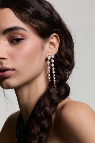 CLOSE UP OF HALF OF A MODEL’S FACE LOOKING AT THE CAMERA, HER HAIR IN A BRAID TUCKED BEHIND HER EAR WEARING LUCIA DOUBLE LINEAR EARRINGS