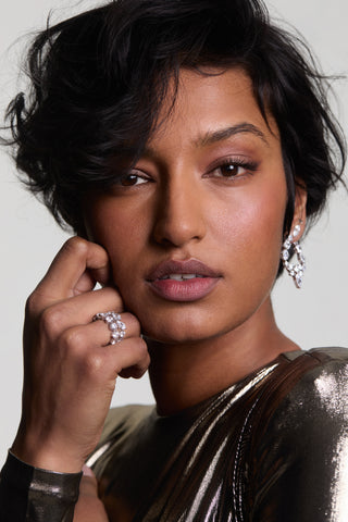 MODEL LOOKING AT THE CAMERA WITH HER HAND RESTING ON HER CHEEK WEARING THE LUCIA MIXED CZ RING SET.
