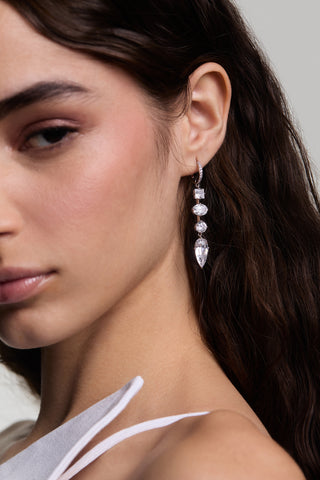CLOSE UP OF HALF OF A MODEL’S FACE LOOKING AT THE CAMERA WITH HER HAIR TUCKED BEHIND HER EAR, WEARING LUCIA LINEAR LEVERBACK EARRINGS