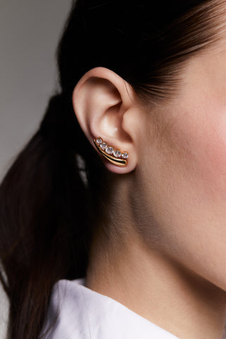 CLOSE UP OF MODEL WEARING PHENOM CLIMBER EARRINGS. HER HAIR IS IN A PONYTAIL.