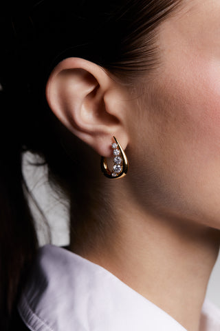 CLOSE UP OF MODEL WEARING . HER HAIR IS IN A PONYTAIL AND WEARING A WHITE COLARED SHIRT.