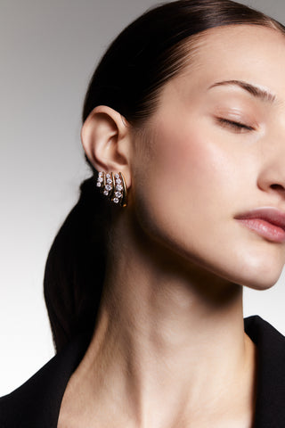 Closeup of model wearing the Phenom Multi J Hoop earrings with her eyes closed and head tilted back.
