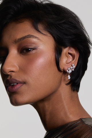 CLOSE UP OF A MODEL WITH SHORT HAIR WEARING RIVIERA CLUSTER DROP EARRINGS AND A METALLIC TOP