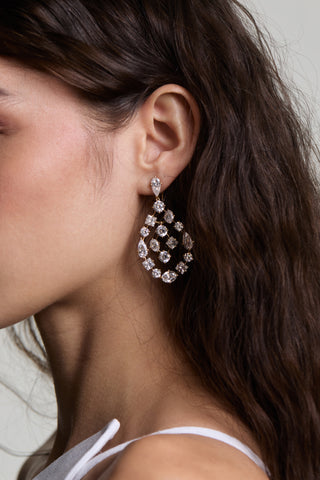 CLOSE UP OF A MODEL’S EAR WEARING THE RIVIERA CHANDELIER EARRINGS, WITH HER HAIR TUCKED BEHIND HER EAR 