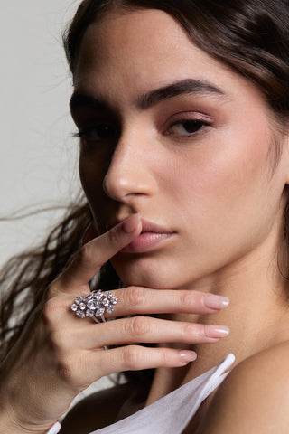 CLOSE UP OF A MODEL WITH HER FINER ON HER LIPS WEARING THE RIVIERA SHIELD RING. 