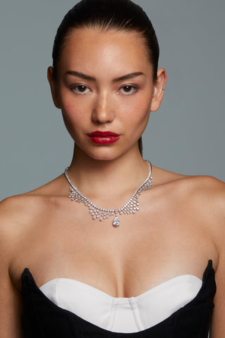 Model in strapless dress wearing silver statement necklace with pear-cut CZ centerpiece
