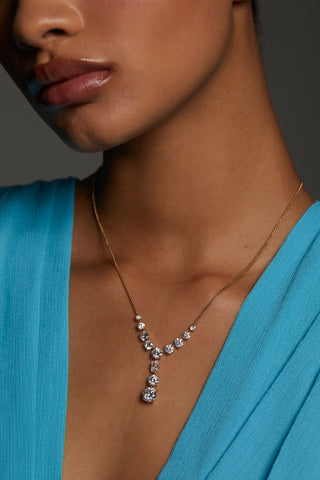 CLOSE UP OF MODEL WEARING STELLAR CZ Y NECKLACE. SHE IS A BLUE VNECK TOP ON. 