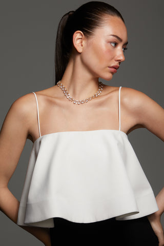 MODEL WEARING STELLAR CZ BOLD COLLAR NECKLACE AND A WHITE SPAGHETTI STRAP TOP AND HAIR PULLED BACK INTO A PONYTAIL. 