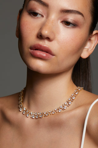 MODEL WEARING STELLAR CZ BOLD COLLAR NECKLACE. CLOSE UP IMAGE OF HER NECKLINE WITH HER HAIR PULLED BACK INTO A PONYTAIL. 