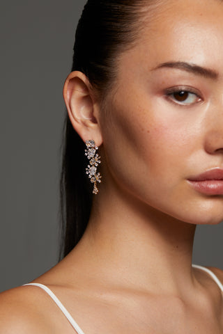 CLOSE UP OF MODEL WEARING STELLAR CASCADE CZ LINEAR EARRINGS WITH HER HAIR PULLED BACK INTO A PONYTAIL. 