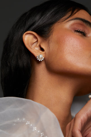 CLOSE UP IMAGE OF MODEL WEARING VENUS PEARL STUD EARRINGS. HER EYES ARE CLOSED AND HER HAIR IS IN A LOW PONYTAIL. 