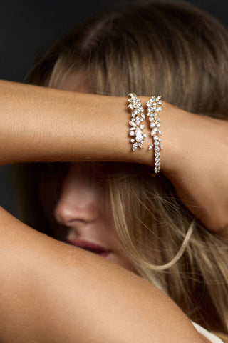 CLOSE UP OF A MODEL LIFTING HER ARM UP TO COVER HER FACE, AS SHE WEARS THE CANNES BOTTOM HINGE BRACELET