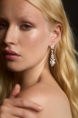 CLOSE UP OF A MODEL'S SHOULDER AS SHE TURNS TO LOOK AT THE CAMERA AND WEARS THE CANNES HOOP DROP EARRINGS