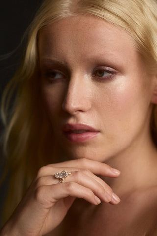 CLOSE UP OF A MODEL LOOKING TO THE SIDE WITH HER HAND LIFTED UP TO HER CHIN, AS SHE WEARS THE CANNES MARQUEE VINE RING