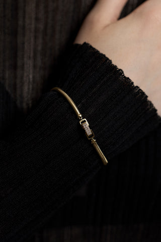 CLOSE UP OF A MODEL’S WRIST AGAINST HER BODY, WEARING A SHEER BLACK DRESS AND THE CELINE SNAKE CHAIN BRACELET LAYERED OVER THE SLEEVE