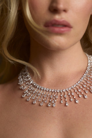 CLOSE UP OF A MODEL’S NECK WEARING THE HERA DRAMA COLLAR NECKLACE AND HER BLONDE HAIR FLOWING IN FRAME