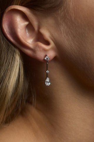 CLOSE UP OF A MODEL’S EAR WEARING THE HERA DROP EARRINGS