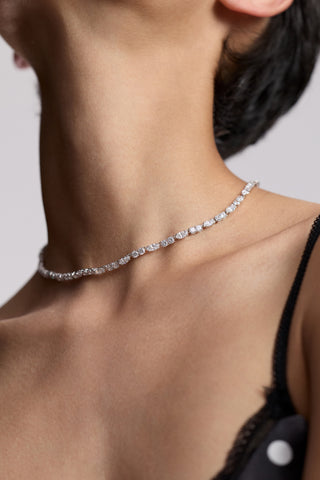 CLOSE UP OF A MODEL’S NECK LOOKING UPWARD, AS SHE WEARS A BLACK CAMI AND THE TWINNIE PATTERN ADJUSTABLE NECKLACE