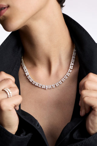 CLOSE UP OF A MODEL’S CHEST WEARING THE TWINNIE STATEMENT COLLAR NECKLACE AND AN OPEN BLACK SHIRT, AS SHE PULLS ON THE SHIRT COLLAR 