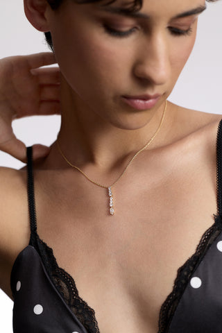 CLOSE UP OF A MODEL’S CHEST AS SHE WEARS A BLACK-AND-WHITE POLKA DOT CAMI AND THE TWINNIE SHORT Y PENDANT NECKLACE