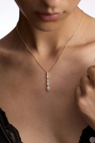 CLOSE UP OF A MODEL’S CHEST AS SHE WEARS A BLACK LACE CAMI AND THE TWINNIE SHORT Y PENDANT NECKLACE