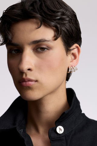 A MODEL WITH SHORT BLACK HAIR LOOKING AT THE CAMERA, AS SHE WEARS A BLACK SHIRT WITH A POPPED COLLAR AND THE TWINNIE MULTI CAGE EARRINGS