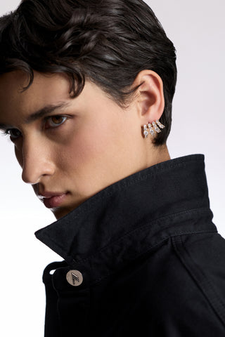 A MODEL WITH SHORT BLACK HAIR LOOKING TO THE SIDE AS SHE WEARS A BLACK SHIRT WITH A POPPED COLLAR AND THE TWINNIE MULTI CAGE EARRINGS