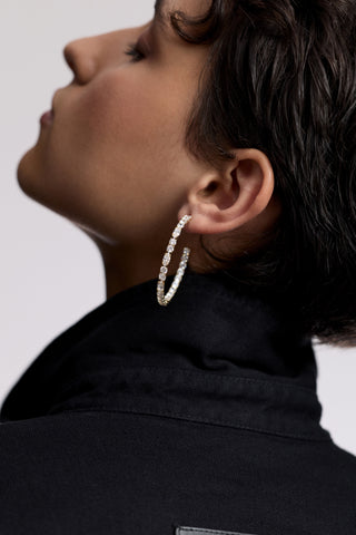 CLOSE UP OF THE BACK OF A MODEL’S HEAD, AS SHE IS LOOKING UPWARD, WEARING A POPPED COLLAR AND THE TWINNIE C HOOP EARRINGS