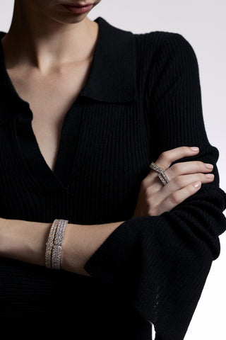 CLOSE UP OF A MODEL’S ARMS CROSSED IN FRONT OF HER, AS SHE WEARS A BLACK SHIRT AND JEWELRY FROM NADRI’S TWINNIE COLLECTION