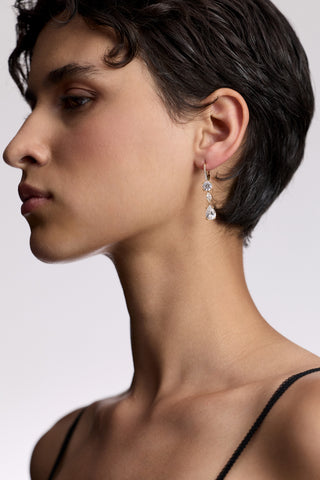 SIDE PROFILE OF A MODEL WITH SHORT BLACK HAIR, AS SHE WEARS A BLACK CAMI AND THE TWINNIE LEVERBACK DROP EARRINGS