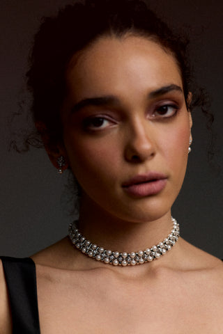 MODEL LOOKING AT THE CAMERA WITH HER HAIR UP IN A BUN, WEARING A BLACK TOP AND THE UNDER THE SEA RETRO PEARL CHOKER NECKLACE