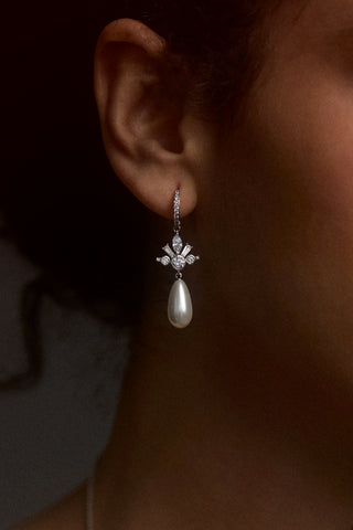 CLOSE UP OF A MODEL’S EAR WEARING THE UNDER THE SEA PEARL TEARDROP LEVERBACK EARRINGS