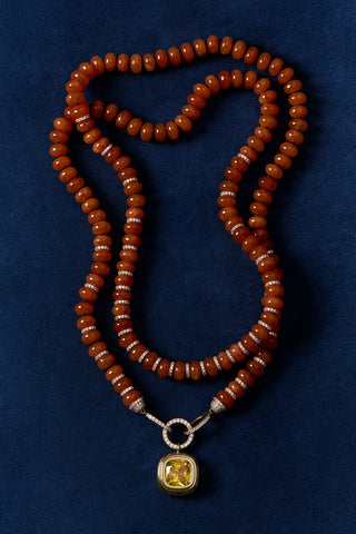 BOUJEE BEADS CARNELIAN LARGE NECKLACE LAID OUT AGAINST A BLUE BACKGROUND