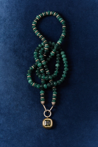 BOUJEE BEADS GREEN LONG NECKLACE WRAPPED UP AGAINST A BLUE BACKGROUND